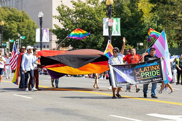 Members of the Latinx community marching and waving flags at 2019 Washington DC Pride parade