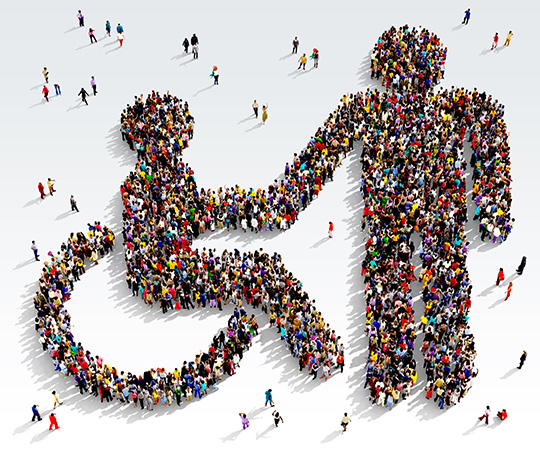 Large and diverse group of people seen from above gathered together in the shape of the symbol for accessibility 