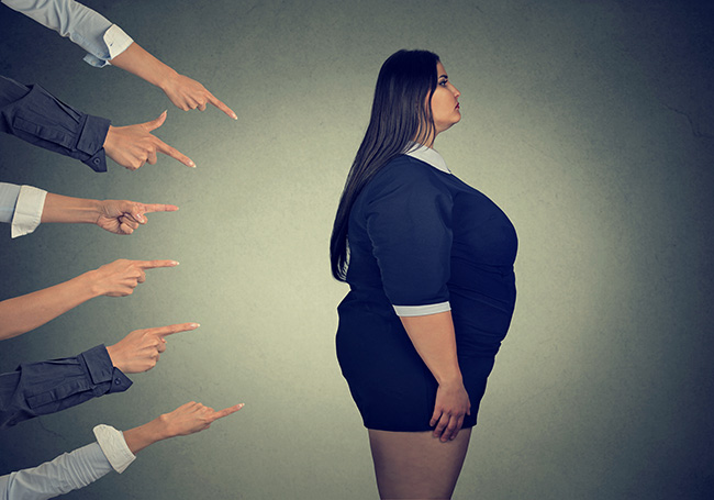 Hands pointing at a woman who might be considered overweight