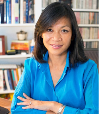 Vietnamese-American Branch Chief, Tram Kim Lam, Ph.D. wearing a blue collared shirt and folding her arms in front of her with a bookshelf in the background