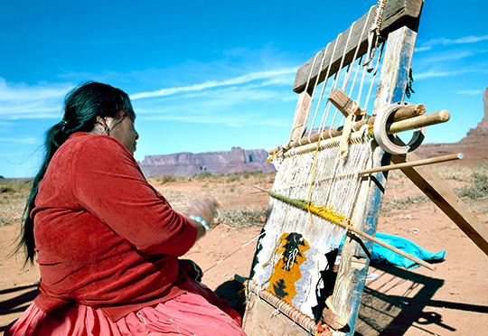 MONUMENT VALLEY, U.S.A.-SEPTEMBER 19,2001: Navajo Indian Woman Weaving Rug at Monument Valley, Utah, U.S.A.