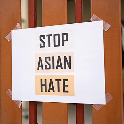 Stop Asian Hate sign taped to a fence.
