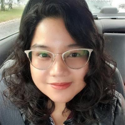 Photo of the author, Mavreen Tuvilla, an Asian-American Scientific Program Analyst, seated in her car wearing glasses.