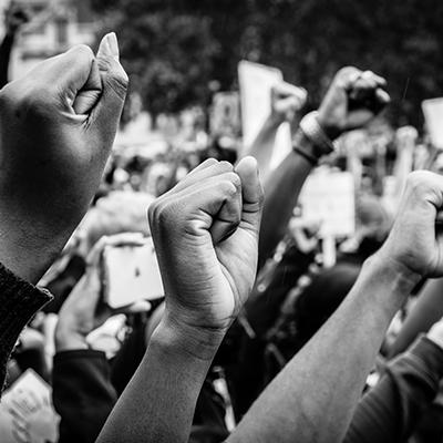 Black and white photo of fists raised in protest