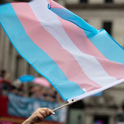 A transgender pride flag being waved at LGBT gay pride march.