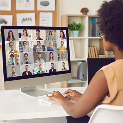 African American woman on a video call with a diverse group of professionals.